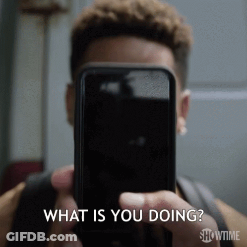 A Man Is Holding A Cell Phone In Front Of His Face And Asking What Is You Doing .. GIF