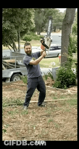 A Man Is Holding A Chainsaw In A Yard And The Name Ted Is On The Bottom GIF