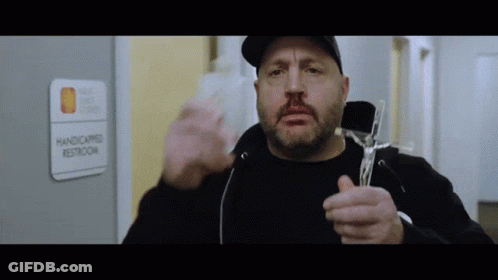 A Man Is Holding A Cross In Front Of A Handicapped Restroom Sign GIF