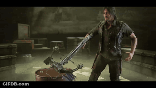 A Man Is Holding A Crossbow In His Hand GIF