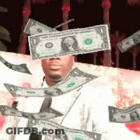 A Man Is Holding A Dollar Bill In Front Of His Head GIF