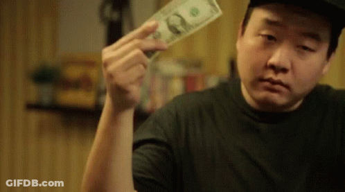 A Man Is Holding A Dollar Bill In His Hand And Looking At It . GIF