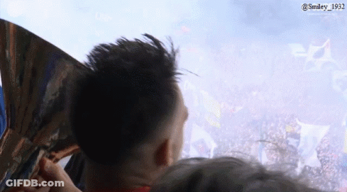 A Man Is Holding A Fan In Front Of A Crowd With The Hashtag Smiley 1932 GIF