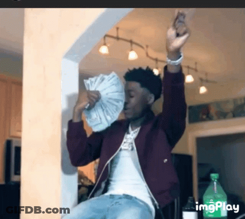 A Man Is Holding A Fan Of Money In His Hand . GIF