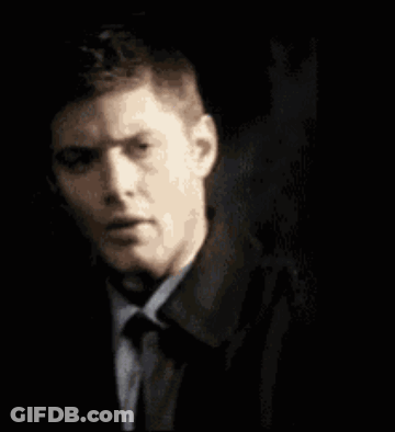 A Man Is Holding A Fbi Badge In Front Of His Face . GIF