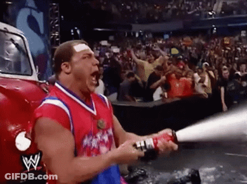 A Man Is Holding A Fire Extinguisher In Front Of A W Logo On The Back Of A Truck GIF
