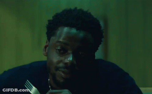 A Man Is Holding A Fork In His Hand And Saying `` Damn '' While Eating . GIF