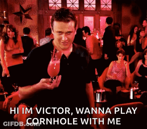 A Man Is Holding A Glass Of Wine And Says Hi Im Victor Wanna Play Cornhole With Me . GIF