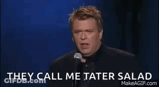 A Man Is Holding A Glass Of Wine And Talking Into A Microphone . GIF