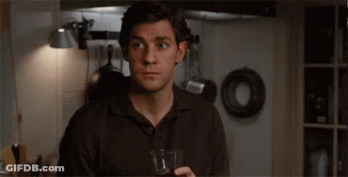 A Man Is Holding A Glass Of Wine In A Kitchen And Says Oh My God . GIF