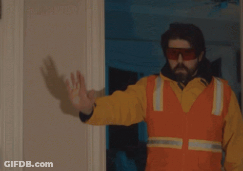 A Man Is Holding A Gun In Front Of A Door That Says Focus GIF