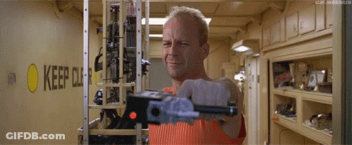 A Man Is Holding A Gun In Front Of A Sign That Says Keep Out GIF