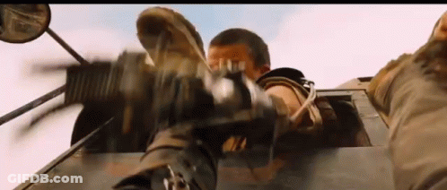 A Man Is Holding A Gun In His Hand While Driving A Car . GIF