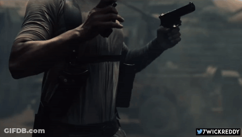 A Man Is Holding A Gun With The Twitter Username 7Wickreddy Visible GIF