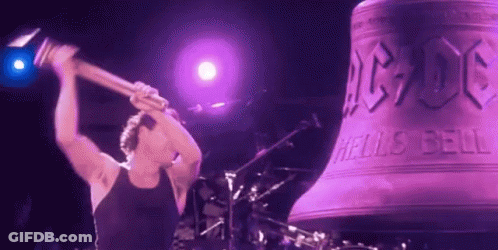 A Man Is Holding A Hammer In Front Of A Large Bell That Says Ac Dc On It GIF