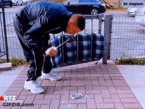 Man Holding Hammer In Front Of Dr. Vagin Sign GIF