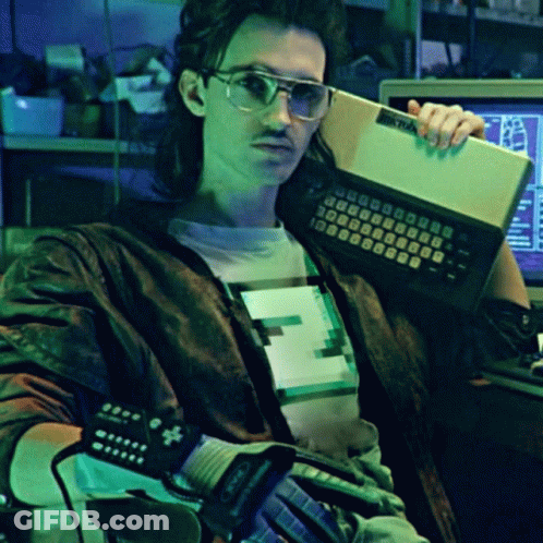 A Man Is Holding A Keyboard That Says Atari GIF