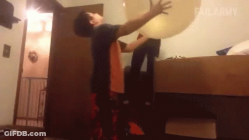 Man Holding Large Balloon In Bedroom GIF