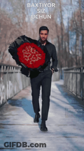 A Man Is Holding A Large Bouquet Of Red Roses With The Words Baxtior Siz Uchun Written On The Bottom GIF