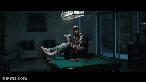 A Man Is Holding A Large Stack Of Money In His Hand . GIF