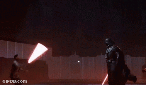 A Man Is Holding A Lightsaber While Another Man Sits On The Ceiling GIF