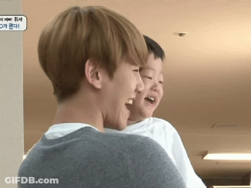 A Man Is Holding A Little Boy In His Arms And Laughing GIF