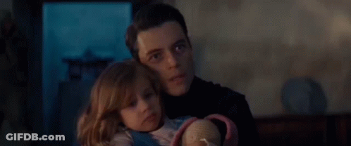 A Man Is Holding A Little Girl In His Arms And The Little Girl Is Looking At The Camera . GIF