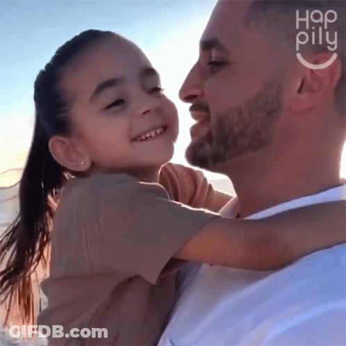 A Man Is Holding A Little Girl In His Arms With The Word Hap Pillu On The Bottom Right GIF