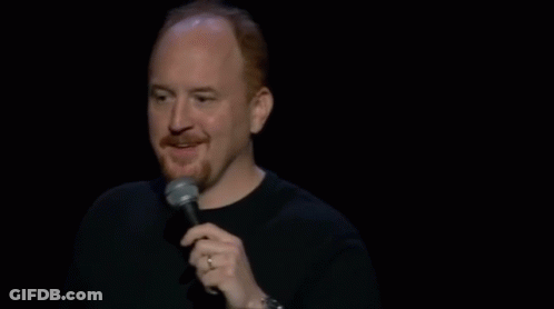 A Man Is Holding A Microphone And Making A Funny Face While Standing On A Stage . GIF
