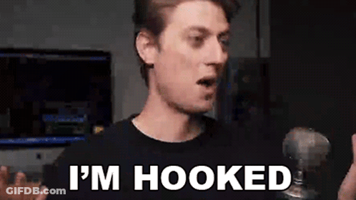 A Man Is Holding A Microphone And Saying `` I 'M Hooked '' GIF