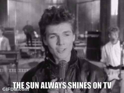A Man Is Holding A Microphone And Singing Into It In A Black And White Photo . GIF
