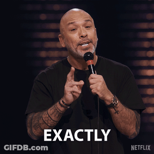 A Man Is Holding A Microphone And The Word Exactly Is Above Him GIF