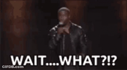 A Man Is Holding A Microphone In Front Of A Crowd And Says `` Wait ... What ? '' GIF