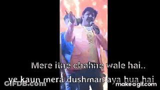 A Man Is Holding A Microphone In Front Of A Crowd While Singing Into It . GIF