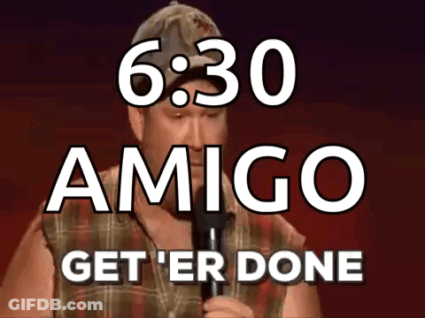 A Man Is Holding A Microphone In Front Of A Sign That Says Amigo Get ' Er Done GIF