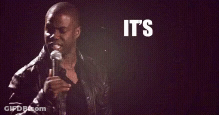 A Man Is Holding A Microphone In Front Of A Sign That Says `` It 'S About To Go '' GIF