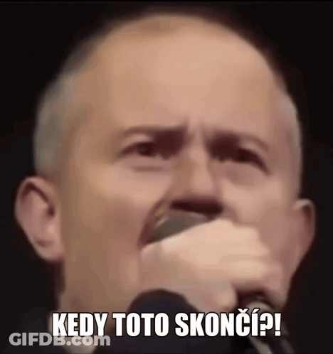 A Man Is Holding A Microphone In His Hand And Making A Funny Face While Singing Into It . GIF
