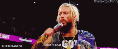 A Man Is Holding A Microphone In His Mouth . GIF