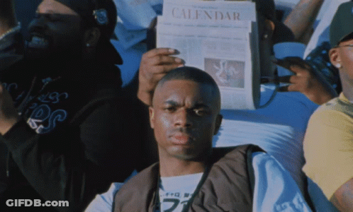 A Man Is Holding A Newspaper That Says Calendar GIF