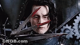A Man Is Holding A Pair Of Scissors With Blood On Them . GIF