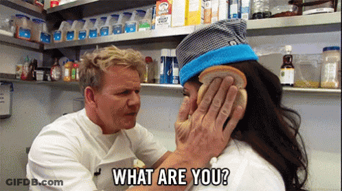 A Man Is Holding A Piece Of Bread Over A Woman 'S Face And Asking Her What Are You . GIF