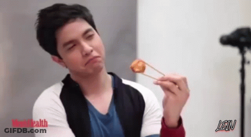 A Man Is Holding A Piece Of Food With Chopsticks And Lean Is Written On The Bottom GIF