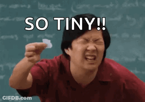 A Man Is Holding A Piece Of Paper In Front Of A Blackboard With The Words So Tiny Written On It . GIF
