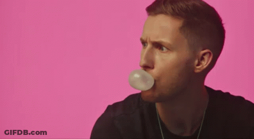 A Man Is Holding A Piece Of Paper In His Mouth . GIF