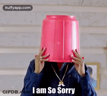 A Man Is Holding A Pink Bucket On His Head . GIF