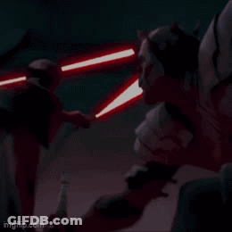 A Man Is Holding A Red Light Saber In A Dark Room GIF