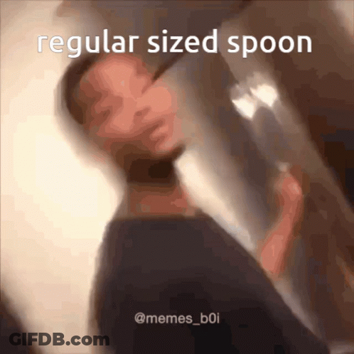 A Man Is Holding A Regular Sized Spoon GIF