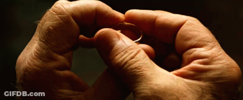 A Man Is Holding A Ring In His Hands GIF