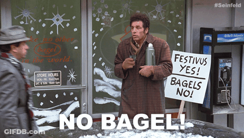 A Man Is Holding A Sign That Says Festivus Yes Bagels No GIF