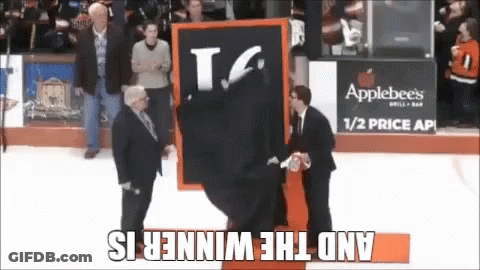 A Man Is Holding A Sign That Says T.g. On It GIF